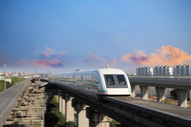 A sleek maglev train speeds along an elevated track, flanked by city buildings and set against a backdrop of a blue sky with pink-tinged clouds.