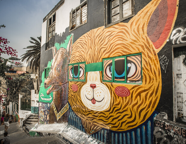A large mural of a cat wearing glasses covers a building wall, flanked by a rhinoceros painting. Palm trees and stairs are in the background. Text reads "DEL FIN AMERICA" and "LOS ANGELES".