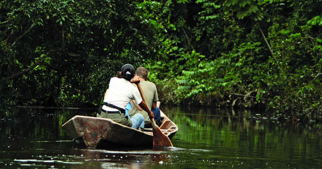 People canoeing down a river in the Amazon rainforest